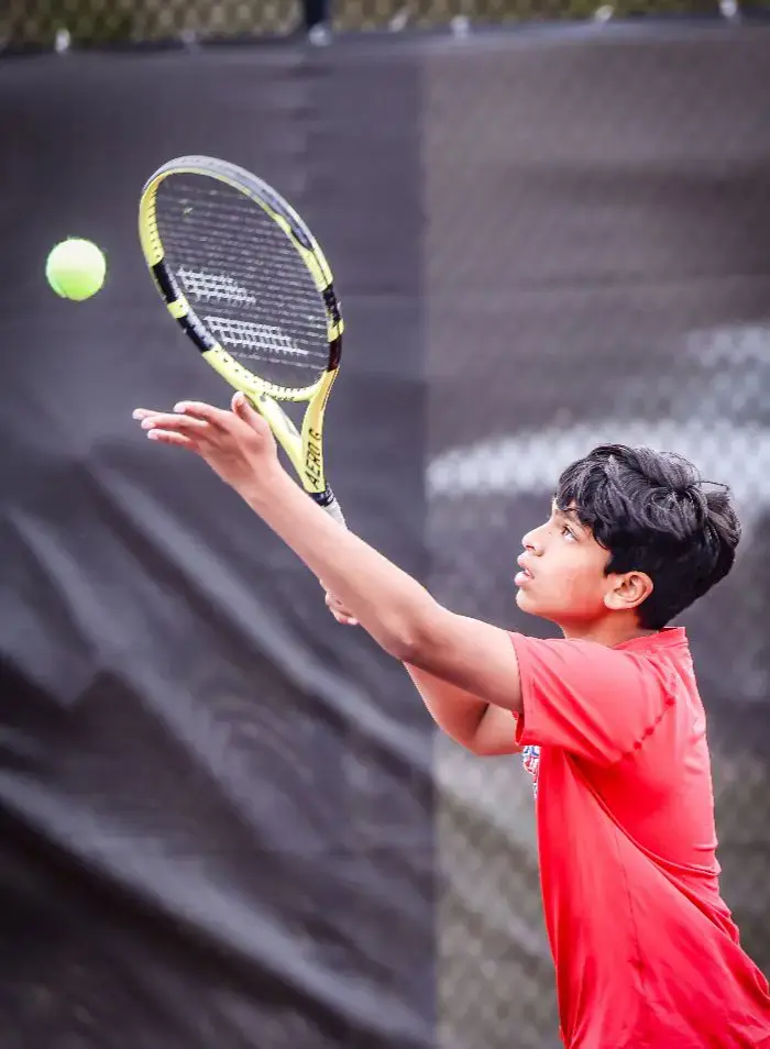 middle school student playing tennis