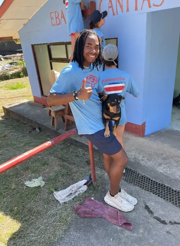 student carrying a dog